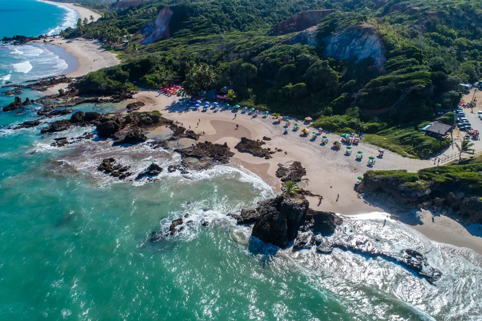 Praia de Tambaba, na Paraíba, tem duas áreas divididas por uma formação rochosa com vegetação, uma praia destinada ao naturismo e outra onde usar roupa ou não é opcional